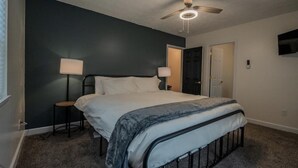 A bedroom with a bed, two bedside lamps, a ceiling fan, and a door. - Experience nature's charm! Retreat near Bryce Resort/George Washington Forest (Basye)