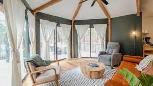 A spacious living area with a ceiling fan, a grey armchair, a wooden coffee table, and a leather sofa. - Experience nature's charm! Retreat near Bryce Resort/George Washington Forest (Basye)