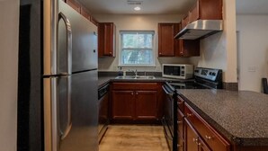 A kitchen with wooden cabinets, stainless steel appliances, a granite countertop, and a window above the sink. - Experience nature's charm! Retreat near Bryce Resort/George Washington Forest (Basye)
