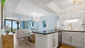 Une cuisine moderne avec des meubles blancs, un îlot central et un coin repas offrant une vue agréable.