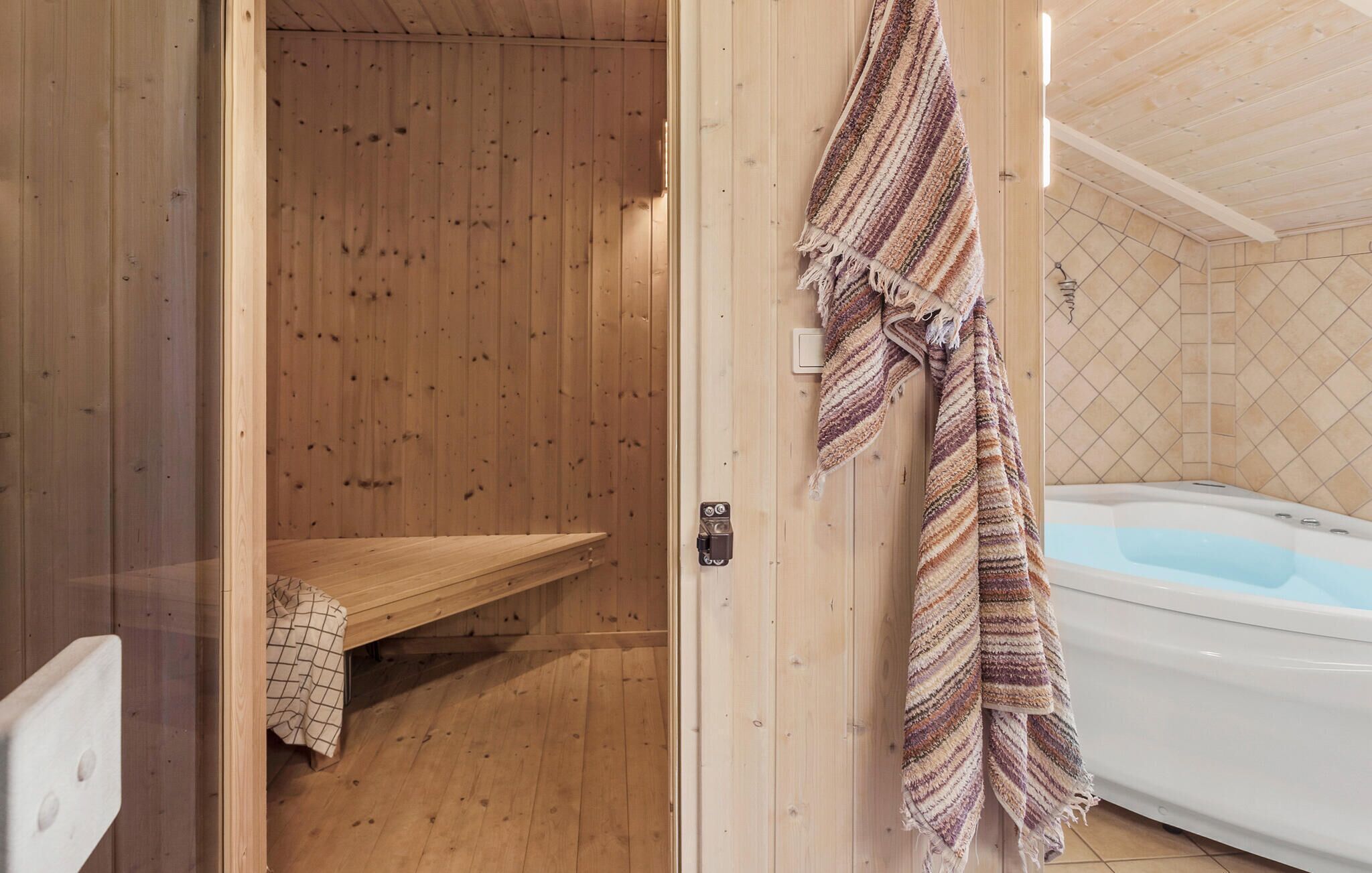 Un sauna en bois, avec un banc et une serviette accrochée au mur.