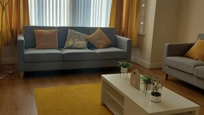 A living room with a sofa, a coffee table, and a lamp.