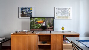 Ein Holztisch mit einem Fernseher, zwei gerahmten Kunstwerken und einem Globus.