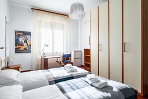 2 habitaciones, escritorio y tabla de planchar con plancha
