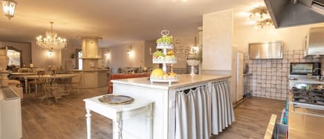 A spacious kitchen with a central island, modern appliances, and elegant lighting fixtures.