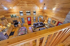 A wooden cabin interior with a kitchen, dining area, and living room. - Oar & Arrow · Wilderness Retreat: Hot Tub, Grill, King Suites (Broken Bow)