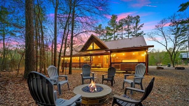 A lodge with a fire pit and outdoor seating. - The Copper Hideout · Hochatown Hideout: Hot Tub, Fire Pit, Pure Relaxation (Broken Bow)