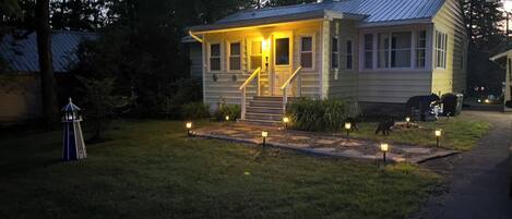 A small, single-story house with a porch and steps leading to the front door.