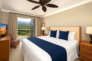 Une chambre d’hôtel avec un grand lit, une télévision, un bureau et une vue sur un paysage.