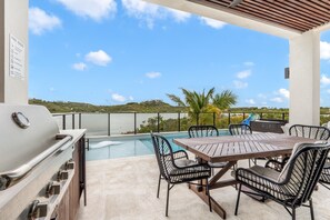 An outdoor patio with a pool, a grill, and a dining area with chairs and a table. - Márohu, 3BR Beach Oasis on Flamingo Lake (Venetian Road Settlement)
