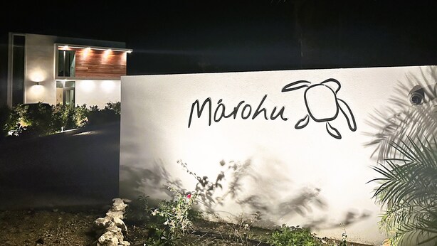 Un edificio moderno con un letrero que dice "Marahu" y una palmera al frente.