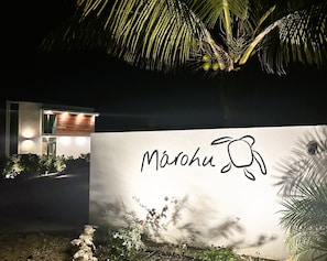 A modern building with a sign that reads "Marahu" and a palm tree in the foreground.