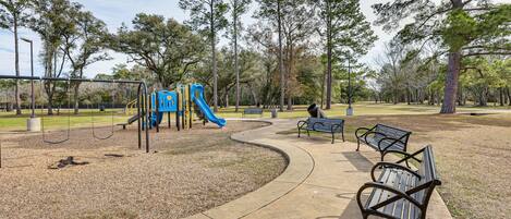 A park with a playground, benches, and a walking path.