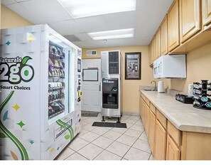 A kitchenette with a vending machine, a water dispenser, and a coffee machine. - Heated pool open year round! Newly lowered rates (Daytona Beach)