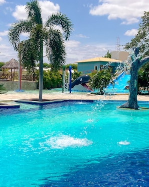 A swimming pool with a water slide and a palm tree. - Hotel e balneário olho d agua do milho (Caraúbas)