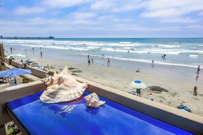 A beach view with a pool featuring seashells.