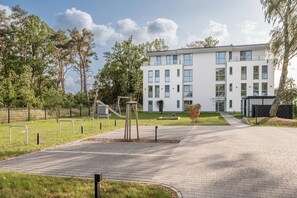 Ein modernes Gebäude mit einem gepflasterten Weg, der zu einem verschlossenen Eingang führt.