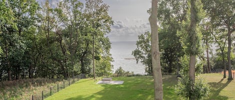 A grassy area with a bench and a view of the water.