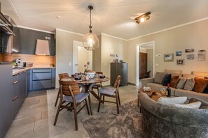 A modern kitchen with a dining area, a sofa, and a coffee table.
