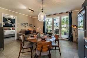 Ein modernes Wohnzimmer mit Essbereich, großen Fenstern und Blick ins Freie.
