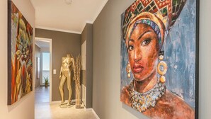 A hallway with artwork on the walls, a mannequin, and a potted plant. - Ferienwohnung Ein Traum am Haff - Hochwertiges Ferienapartment in Ruhiger Süd-west Lage mit Sauna, (Zirchow)