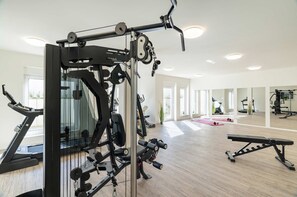 A gym with exercise equipment, a treadmill, and a bench. - Ferienwohnung Klippenblick (Garz)