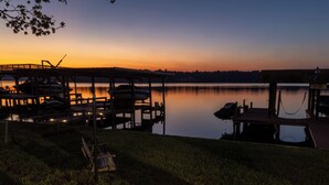 Ein Boot liegt im Abendlicht an einem Seeufer festgemacht.
