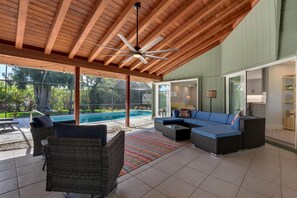 A covered patio with a pool, outdoor seating, and a ceiling fan. - Welcome to Clipper Casa, your gateway to the ultimate vacation experience! (Naples)