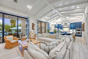 A spacious living area with a large sofa, a wooden coffee table, and wicker chairs.