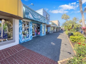 A street with shops, including a store with a blue facade and a sign that reads 'Ben Jerry's.'