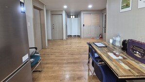 Eine moderne Küche mit Holzarbeitsplatte, einem Kühlschrank und einem Essbereich mit Stühlen.