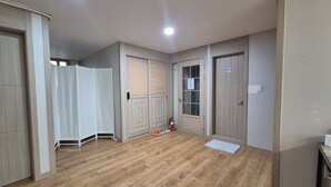 Ein Zimmer mit Holzboden, einer weißen Trennwand und zwei Glastüren.