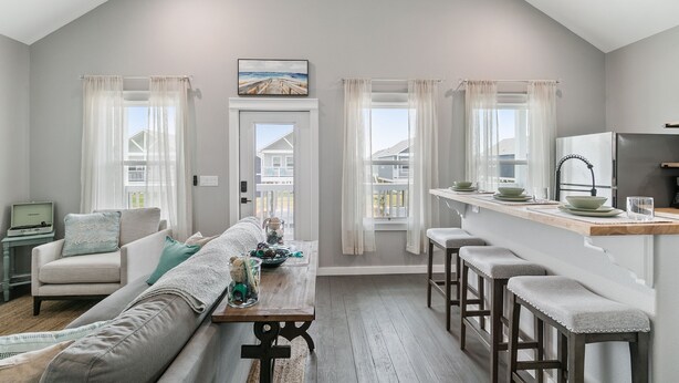 A modern kitchen with a wooden countertop, bar stools, and a view of the outdoors. - Schipps Creek - Ocean & Bay Views (Bolivar Peninsula)