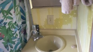 A bathroom with a sink, mirror, and towel hanging on the wall.