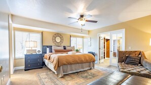 A bedroom with a bed, dresser, and a ceiling fan. - Spacious 6 BR Extended Stay (North Salt Lake)