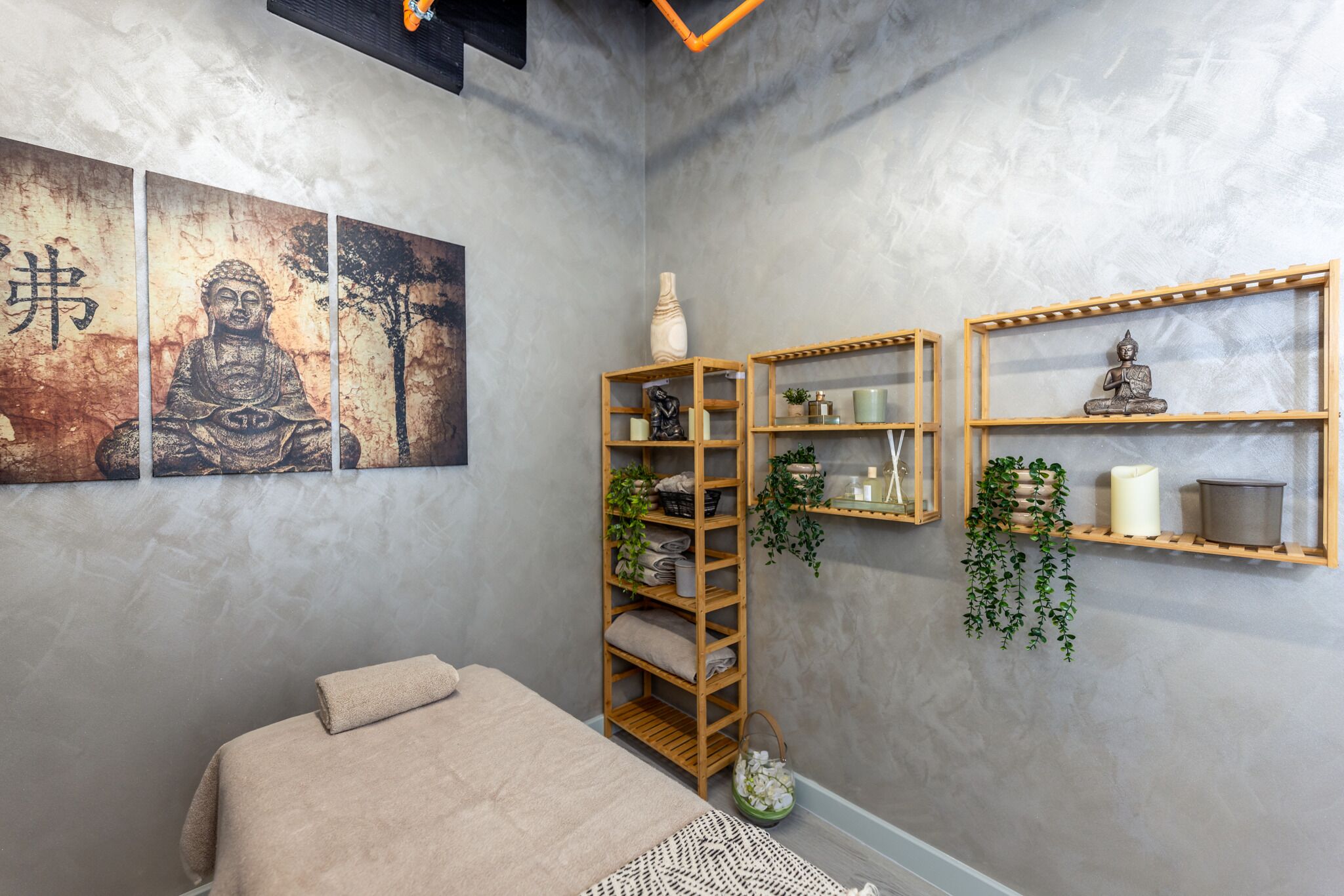 A room with a bed, wooden shelves, and wall art.