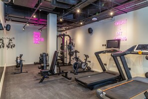 Ett modernt gym med löpband, styrketräningsmaskiner och en motionscykel.