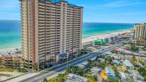 Ein Hochhotel mit zahlreichen Stockwerken, Blick auf den Strand und einer Straße im Vordergrund.