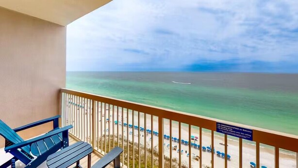 Ein Balkon mit Blick auf das Meer, ein Stuhl und ein Schild mit Text.