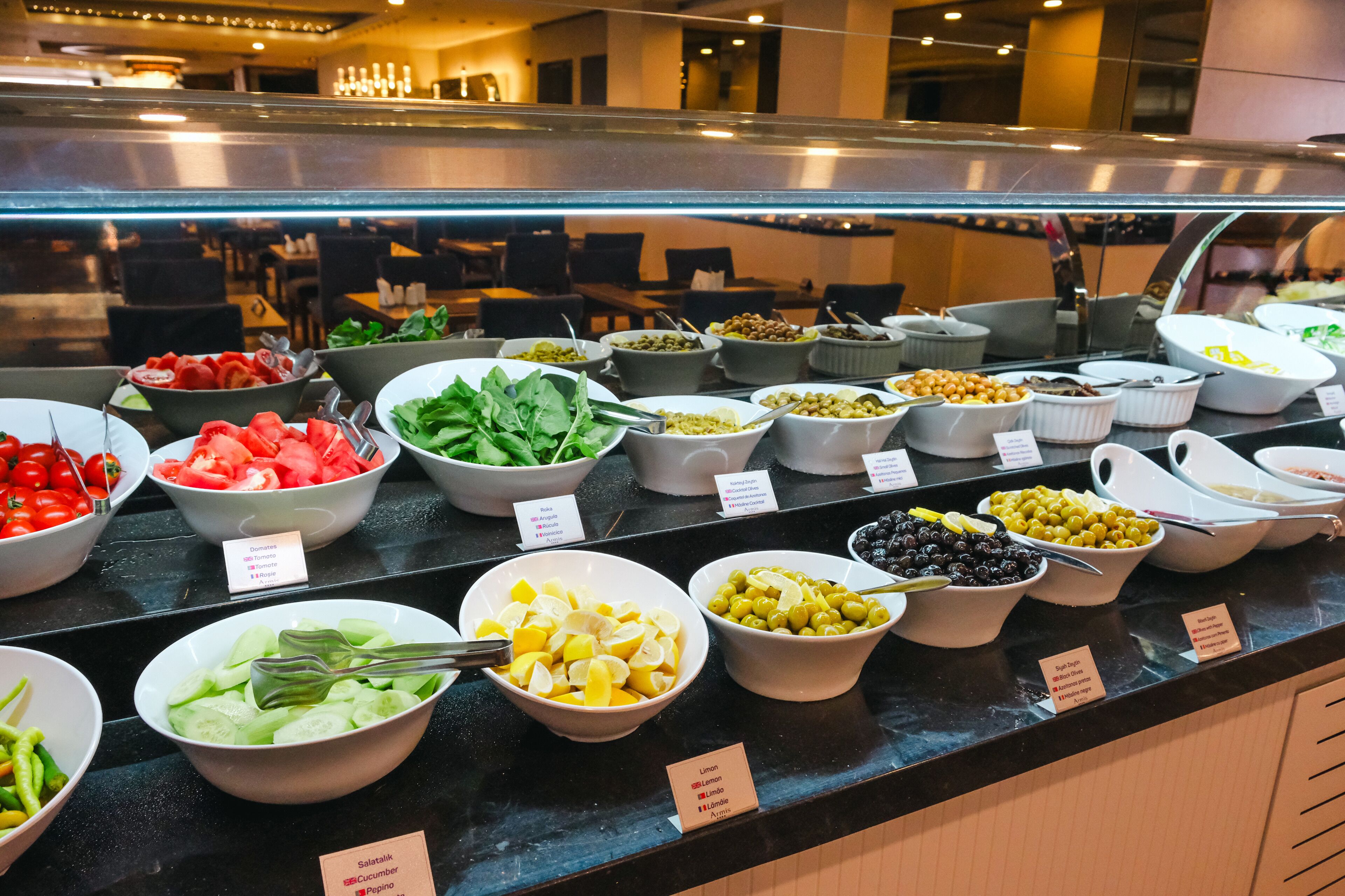 Een buffet met diverse eetopties, waaronder salades, fruit en groenten.