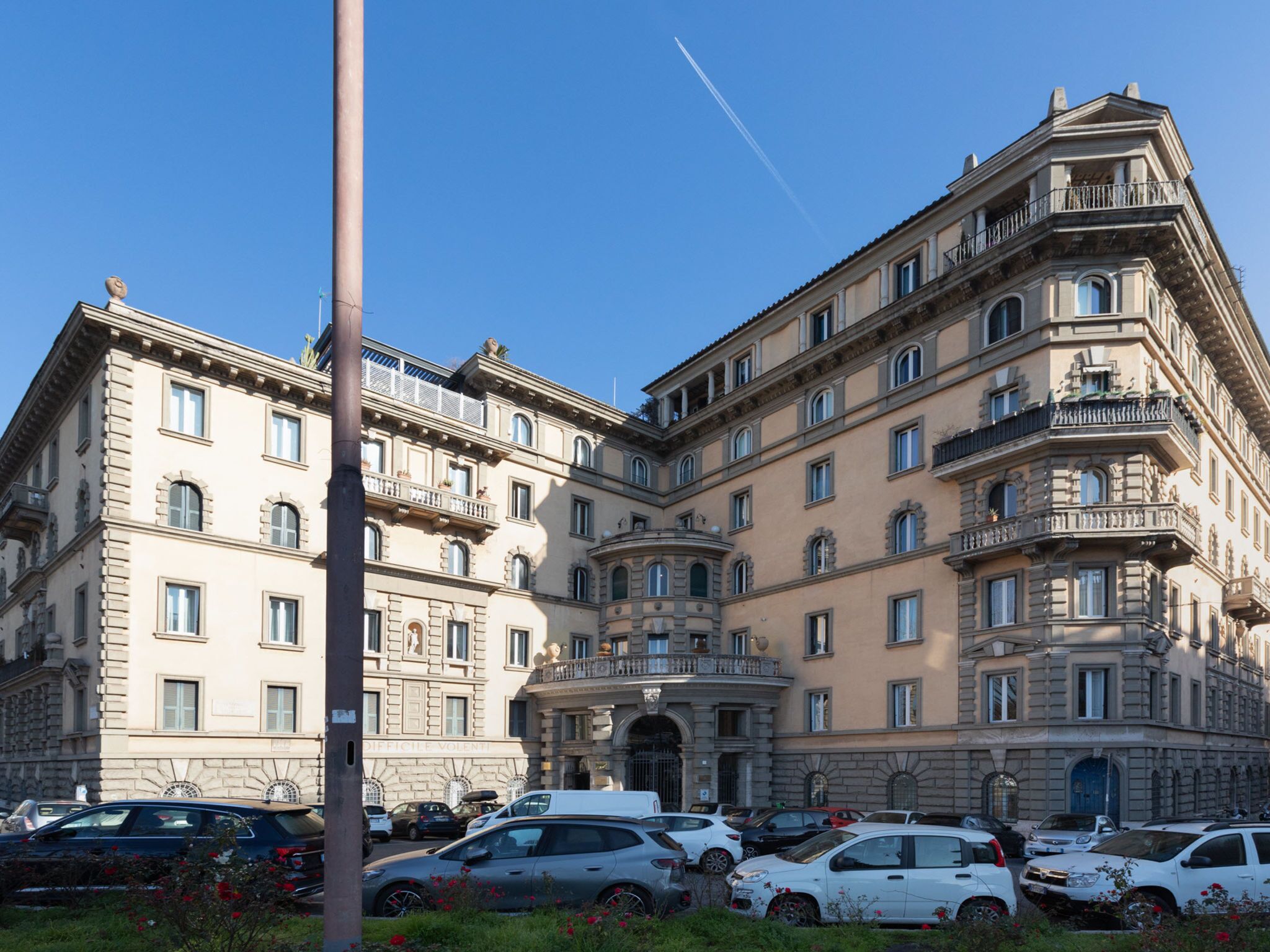 A multi-story building with a classical architectural style, featuring balconies and a central entrance.