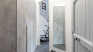 Un pasillo con una escalera moderna, una puerta y un cuadro en la pared.