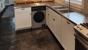Une cuisine moderne équipée d’un lave-vaisselle, d’un évier et d’un ventilateur de plafond.