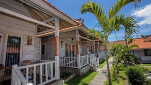A row of wooden houses with tiled roofs and white railings. - Blue Sky Villa Ceningan by ABM  (Ceningan Island)