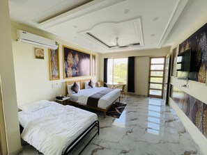 A hotel room with two beds, a ceiling fan, a TV, and large windows. - Paradise Woodland Resort Chintpurni (Dera Gopipur)