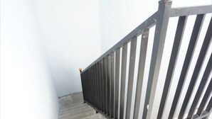 A staircase with a metal railing and a light fixture at the top. - SPOT ON 93611 Kost Pak Suyatno Syariah 2 (Ponorogo)
