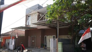 A construction site with a partially built house, workers, and construction materials. - SPOT ON 93611 Kost Pak Suyatno Syariah 2 (Ponorogo)