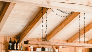 A kitchen with wooden beams, a hanging light fixture, and a coffee machine. - Apartment 'Katie' with Mountain View, Private Terrace and Wi-Fi (Hopfgarten)
