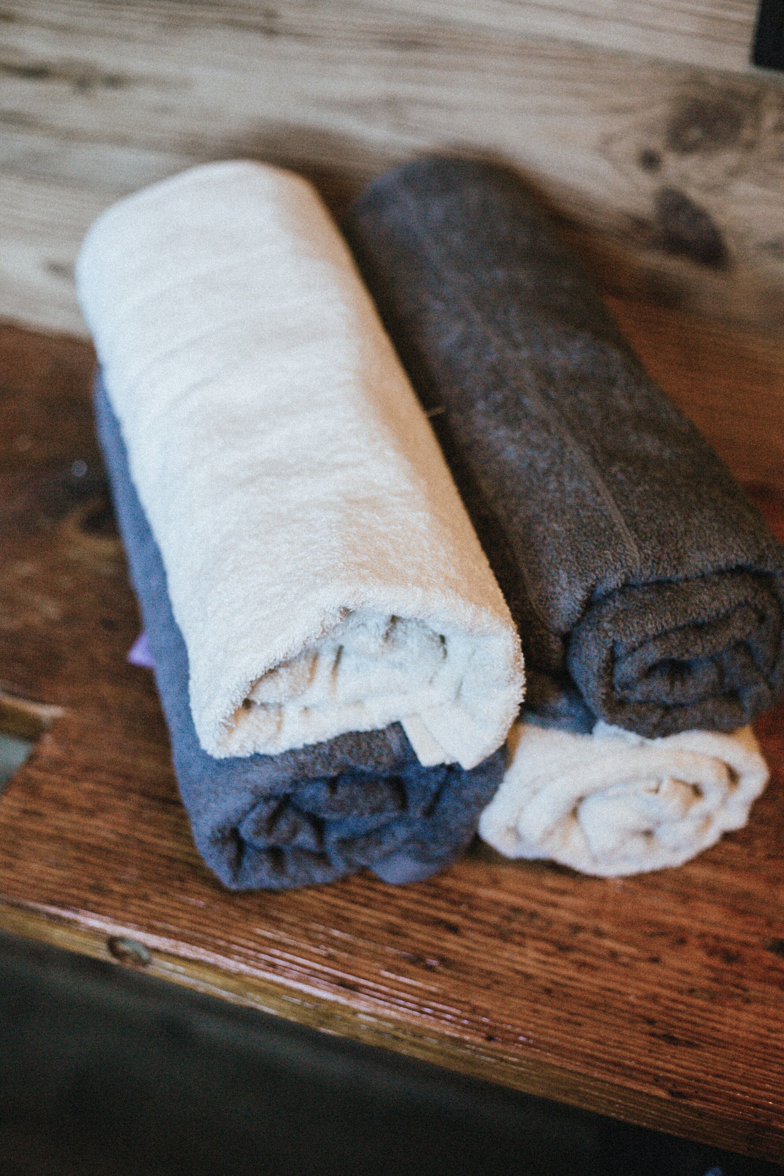 Une surface en bois avec des serviettes enroulées.