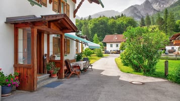 A building with a wooden facade, outdoor seating, and a mountain backdrop.
